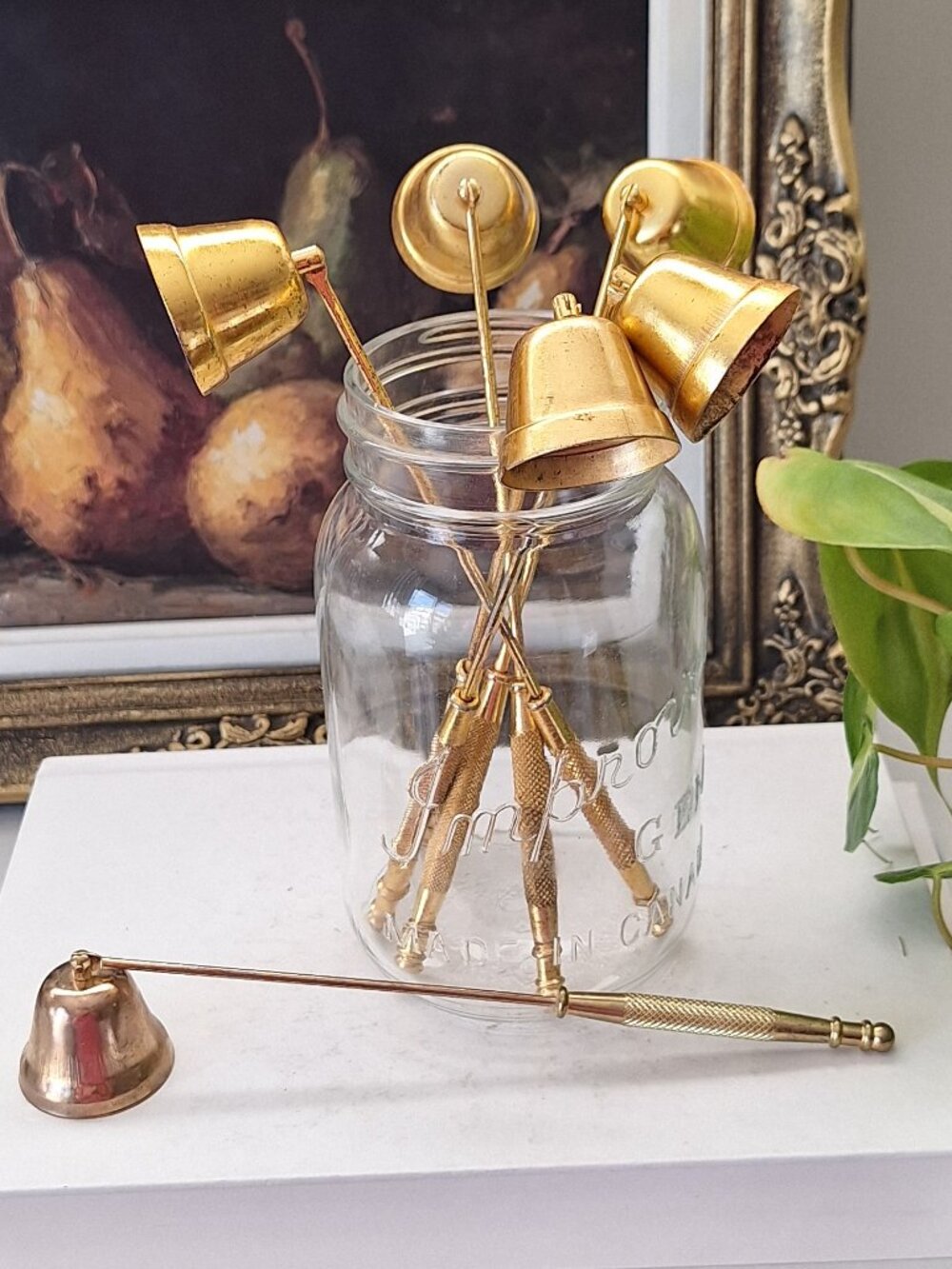 Bundle of Vintage brass look candle snuffers in a vintage glass jar